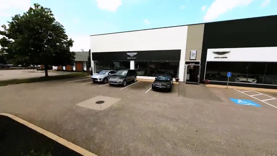 An FPV fly-through of a luxury automotive showroom — one continuous take threading the floor and the cars.